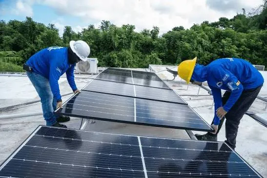 Instaladores colocando paneles solares en el techo de una residencia en Puerto Rico